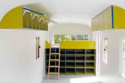 Wall cupboard built into the curved roof and loft with access via a hanging stepladder and storage shelves below, panorama windows.